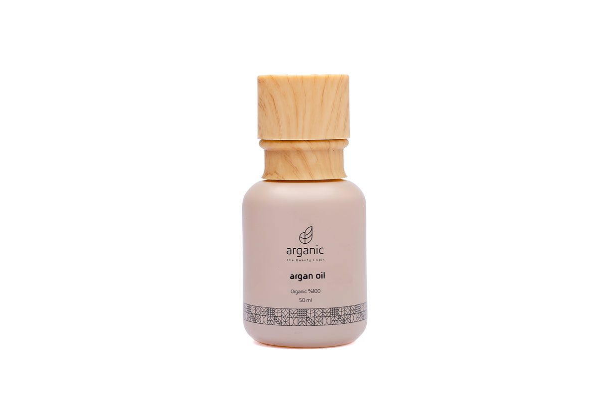 Bottle of argan oil with wooden cap, beige label, isolated on white.